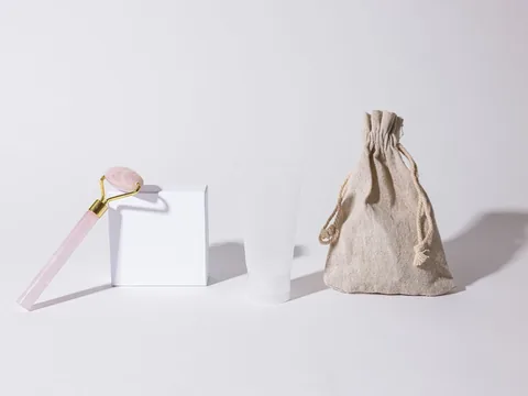 A jade roller, a blank card and a linen pouch styled together in one consistent set.
